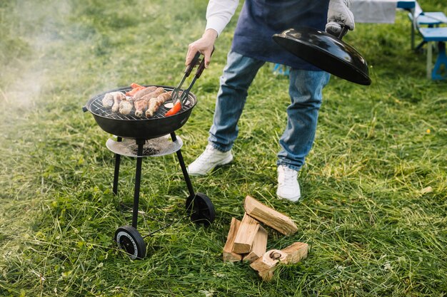 Homme avec un barbecue dans la nature