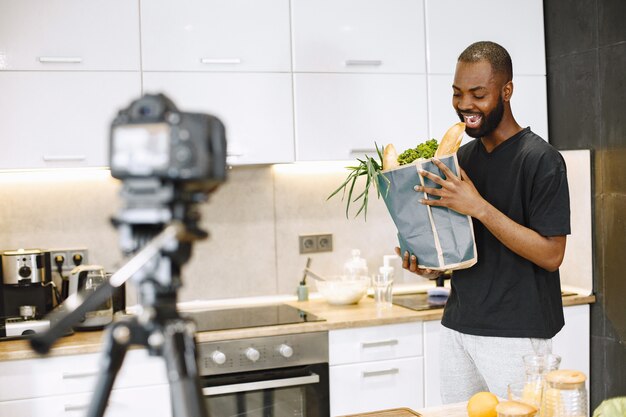 Homme barbu afro-américain souriant et tenant un paquet avec de la nourriture