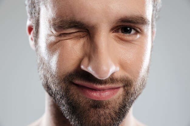 Homme barbu face à un clin de œil