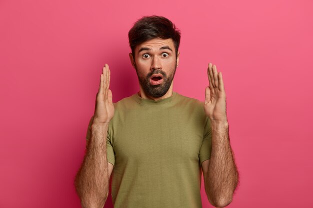 Un homme barbu impressionné façonne un gros objet, raconte la taille de la boîte présente