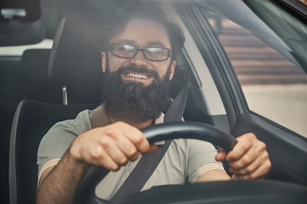 Un homme barbu moderne conduisant une voiture