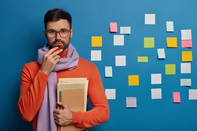 Homme barbu organisant ses tâches à l'aide de notes autocollantes