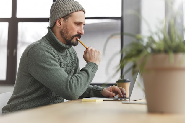 Homme barbu portant un pull chaud tricoté et un chapeau