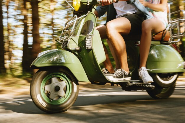 Homme barbu en scooter avec une petite amie à l'extérieur