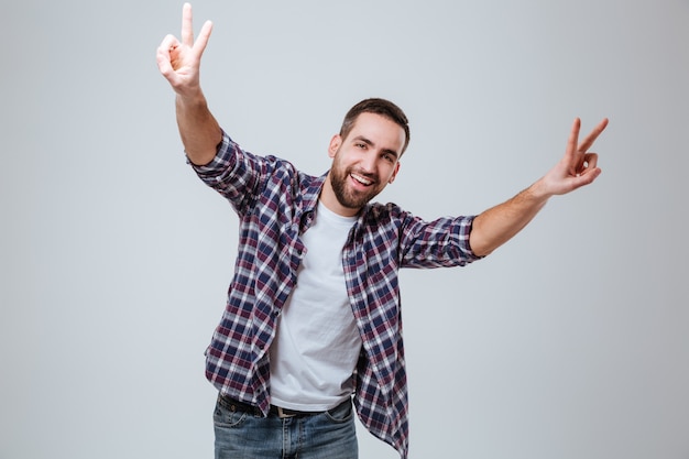 Homme Barbu Souriant En Chemise Montrant Des Signes De Paix