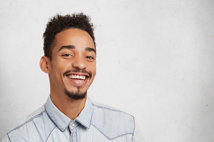 Photo gratuit homme barbu souriant avec visage ovale, coiffure à la mode, être heureux