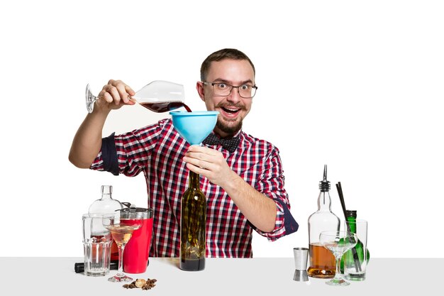 Homme barman expert fait un cocktail au studio isolé sur blanc