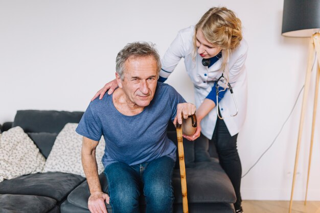 Homme avec un bâton dans la maison de retraite