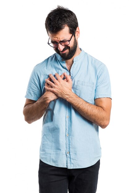 Homme beau avec des lunettes bleues avec une douleur cardiaque