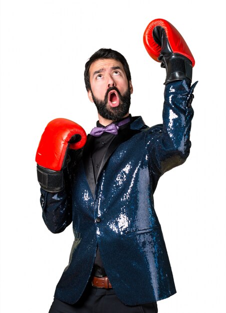 Homme beau avec une veste en paillette avec des gants de boxe