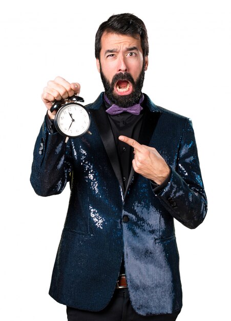 Homme beau avec une veste en paillette tenant horloge vintage