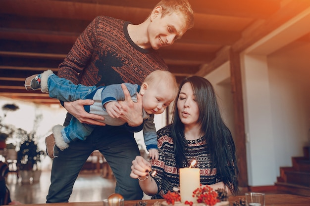 L&#39;homme avec un bébé dans ses mains en regardant sa femme allumant une bougie