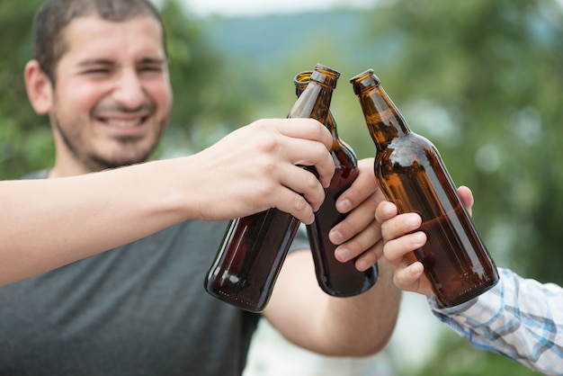 Homme biberon avec des amis dans la nature