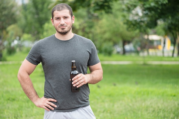 Homme, à, bière, debout, dans parc