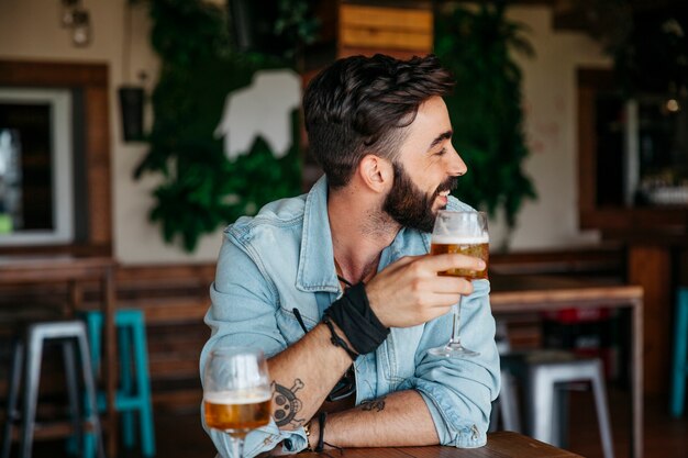Homme avec de la bière regardant vers sa gauche