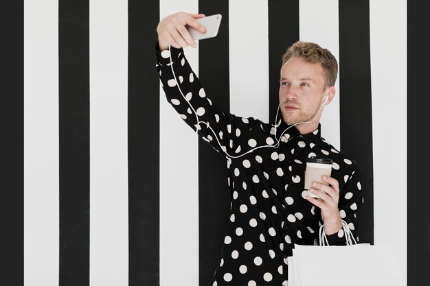 Homme blond avec une chemise prenant un selfie