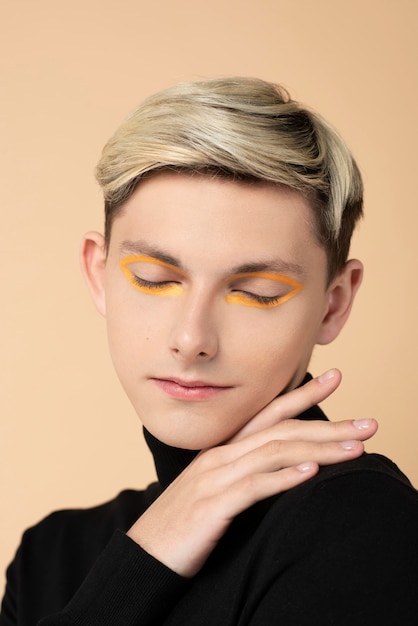 Homme blond portant un eye-liner orange