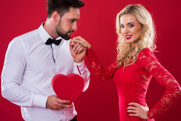 Homme avec boîte en forme de coeur tenant la main de la femme