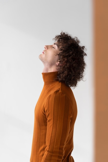 Homme bouclé avec chemisier marron posant