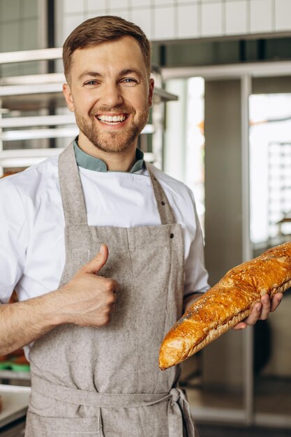 Homme boulanger avec du pain frais à la maison du boulanger