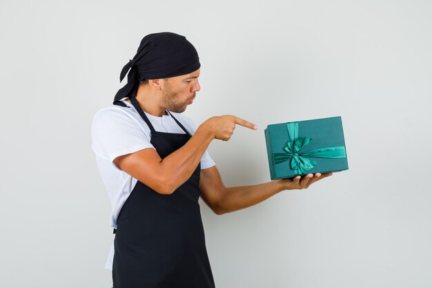 Homme de boulanger pointant sur une boîte-cadeau en t-shirt