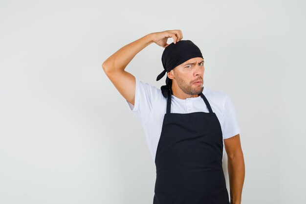 Homme boulanger se gratte la tête en t-shirt