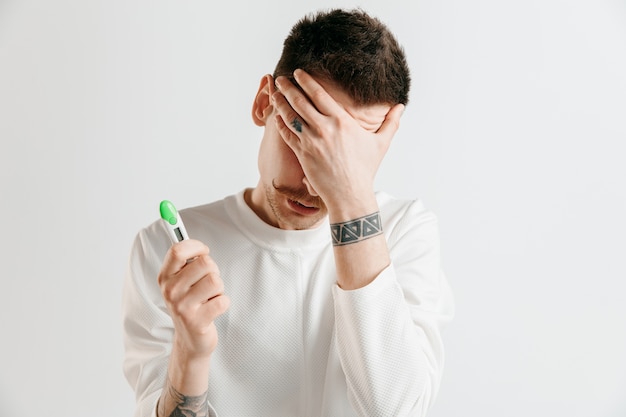 Homme bouleversé à la recherche de test de grossesse.