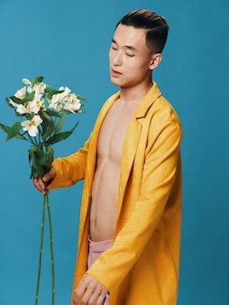 Homme avec un bouquet de fleurs blanches sur fond bleu cadeaux de romance veste torse nu