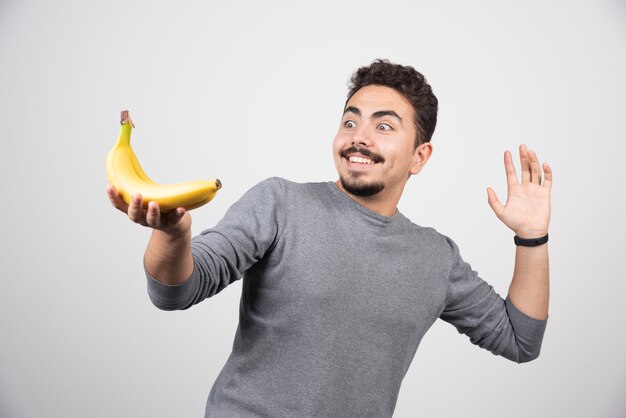 Homme brune regardant la banane avec bonheur.