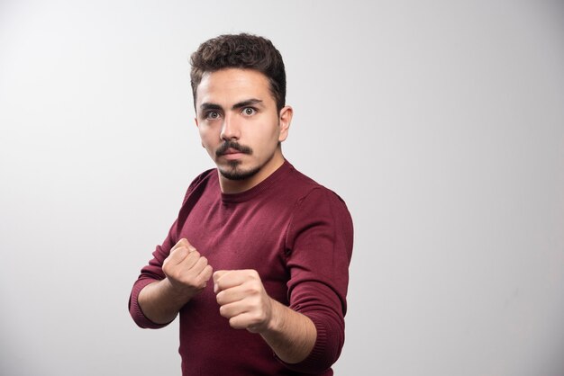 Un homme brune sérieuse debout et posant