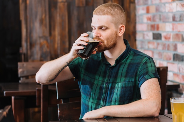 Photo gratuite homme buvant une boisson alcoolisée au bar