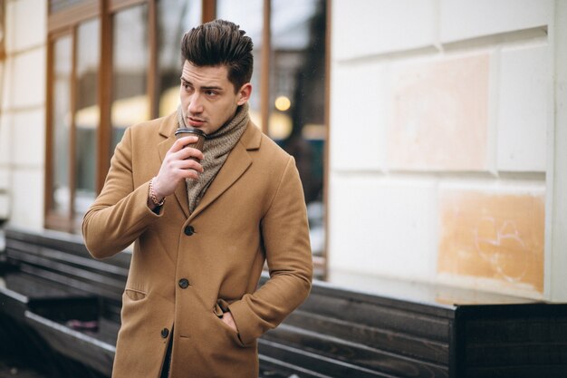 Homme avec un café dehors en hiver