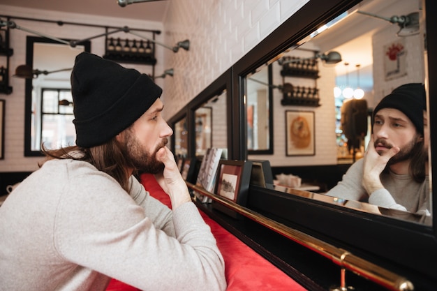 Homme calme posant près du miroir