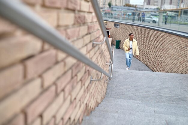 Homme avec caméra monter les escaliers à la recherche de côté