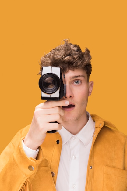Homme avec un caméscope dans une scène jaune