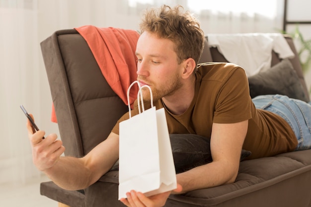 Photo gratuite homme sur canapé avec smartphone