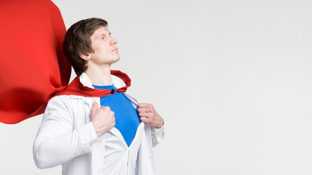 Photo gratuite homme avec cape rouge et blouse de laboratoire