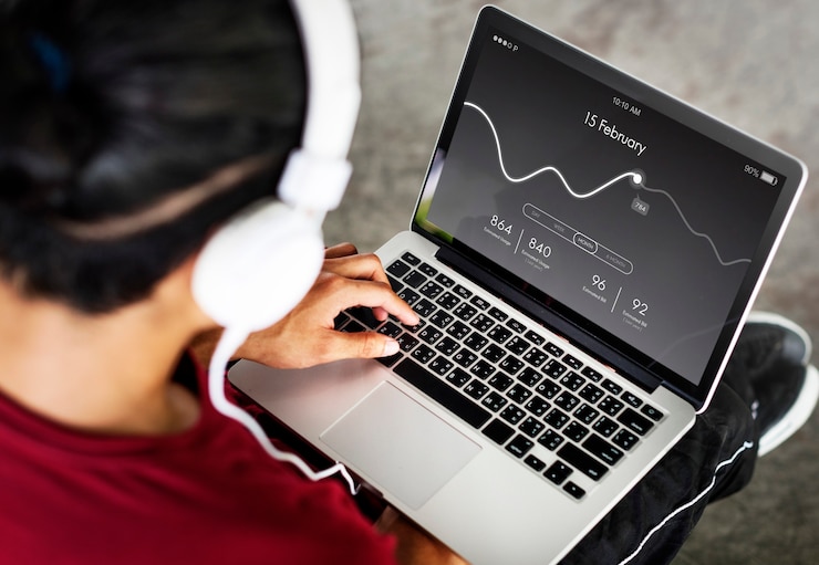 Photo gratuit homme avec un casque analyse les statistiques en ligne