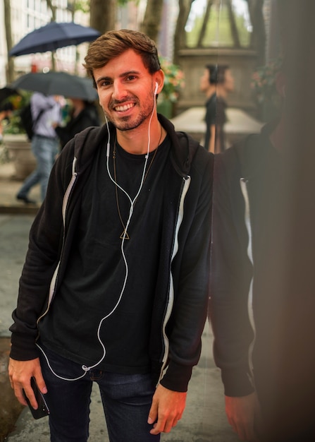 Photo gratuite homme avec un casque appuyé contre un mur