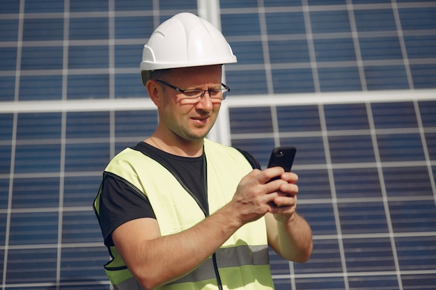 Homme Avec Un Casque Blanc Près D'un Panneau Solaire