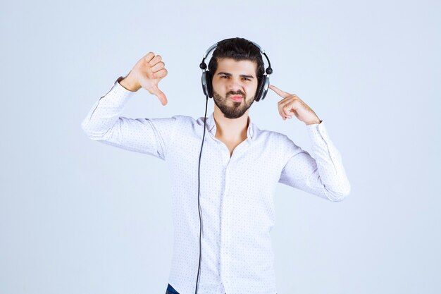 Homme avec un casque montrant le pouce vers le bas