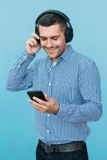 Homme avec casque et smartphone en milieu urbain