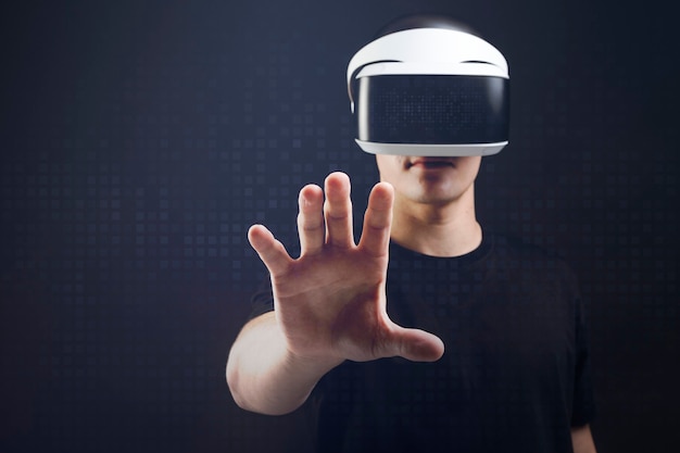 Homme avec un casque VR touchant un objet invisible