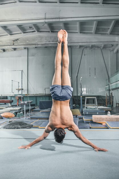 Homme caucasien acrobatie gymnastique équilibre posture au gymnase