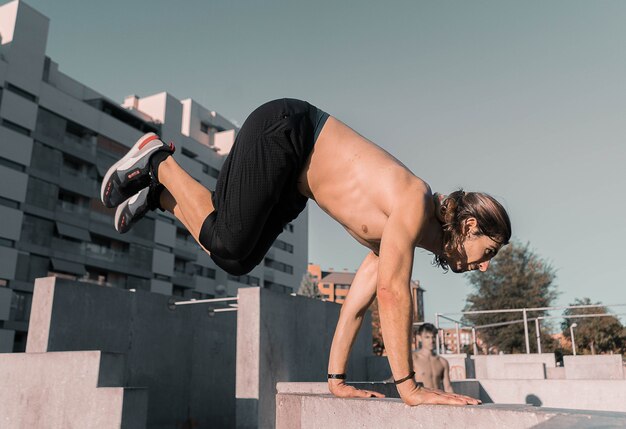 Homme caucasien athlétique faisant du parkour sur des bâtiments