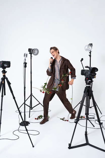 Photo gratuite homme chantant avec des fleurs plein coup