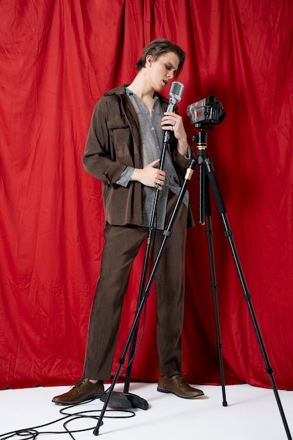Photo gratuite homme chantant avec microphone plein coup