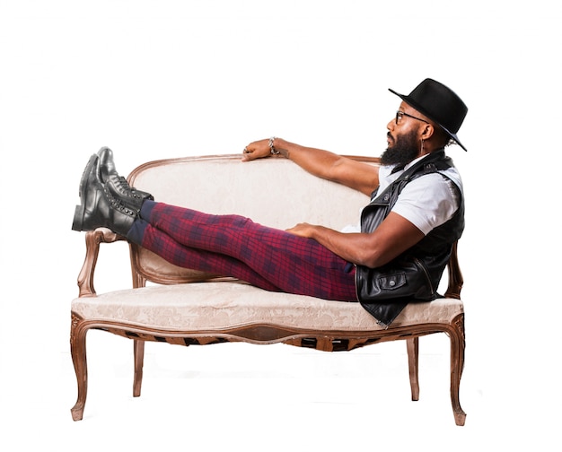 L&#39;homme avec un chapeau allongé sur un canapé