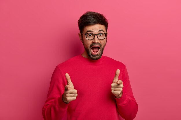 Un homme charismatique excité et non rasé pointe directement