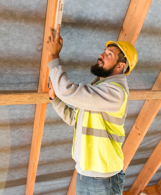 Photo gratuite homme charpentier travaillant sur le côté